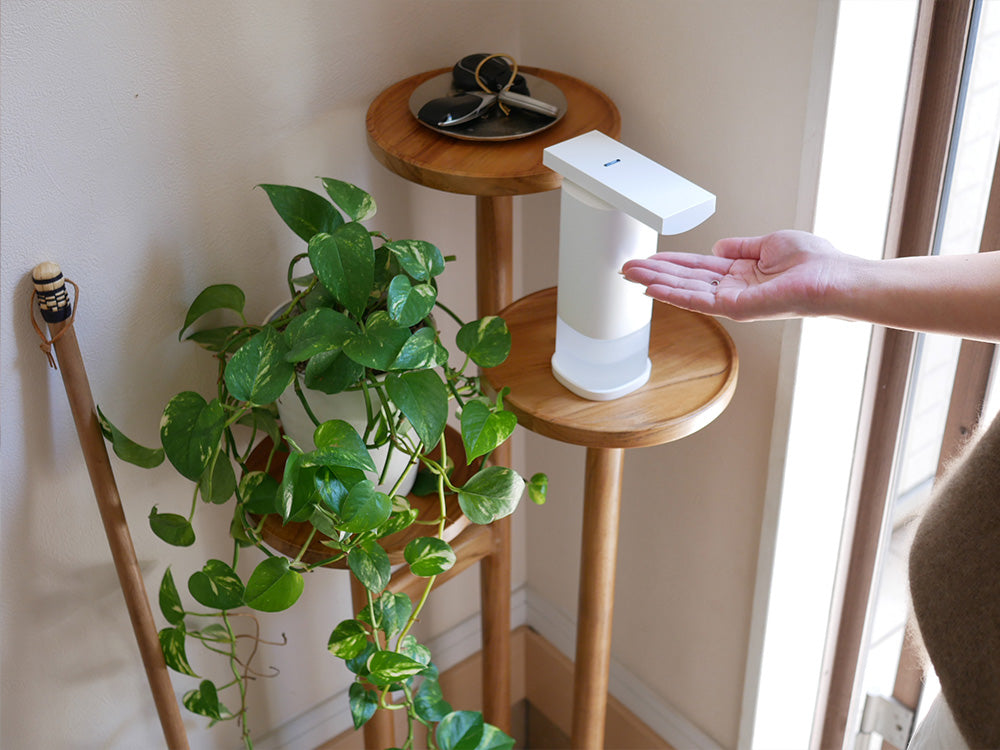 花瓶に活けられたゼラニウムと共に配置されたプラスマイナスゼロ オートディスペンサー