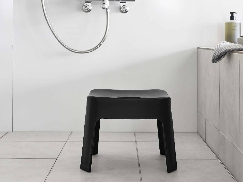 銀色のプラスチック製マグネット風呂イス SH25が浴室の平らな壁面に取り付けられている様子