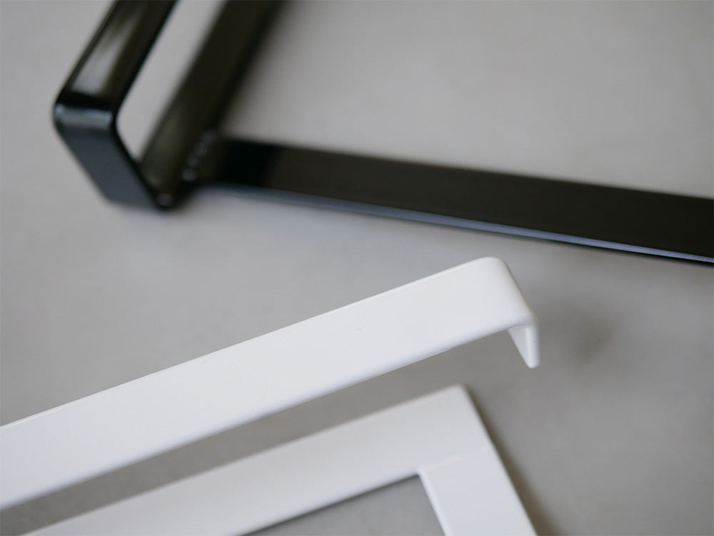 銀色のタワーキッチンシンク下収納扉タオルハンガーが扉に取り付けられ、タオルが掛かっている様子