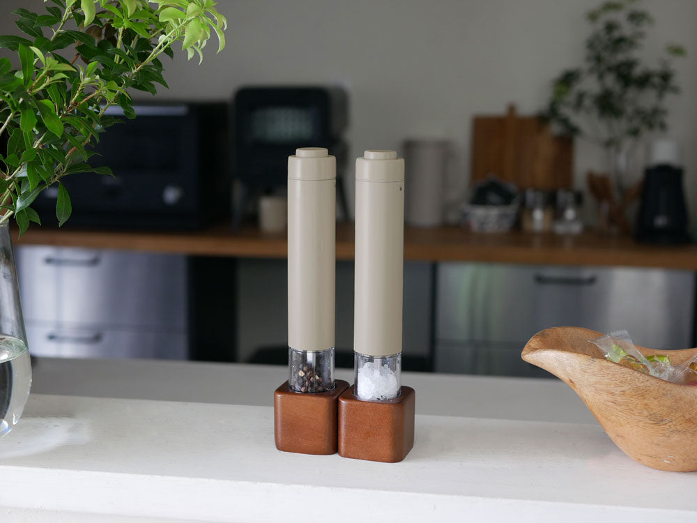 アカシアスタンドに置かれたレコルトの電動ソルト＆ペッパーミルと花瓶、キャンドルホルダーが並ぶ静物写真