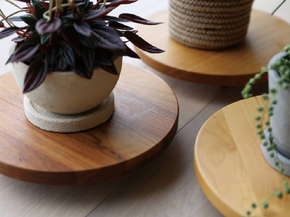 高野木工のホワイトオークまたはウォルナット製PLANTER BASEと陶器の花鉢がテーブル上に美しく配置されている様子