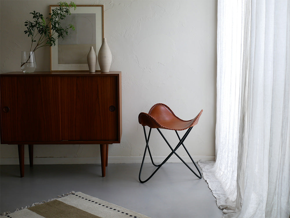 木製フローリングのインテリアに置かれた【WRAPS】アイアンレザースツール