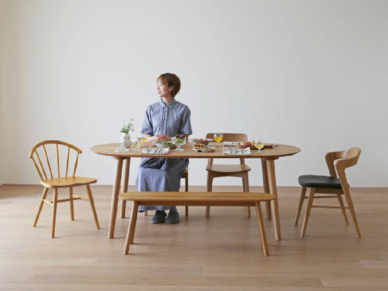 高野木工のホワイトオーク製RUBEダイニングテーブルと椅子が配置され、木材の質感と植物が調和したダイニングルームの風景