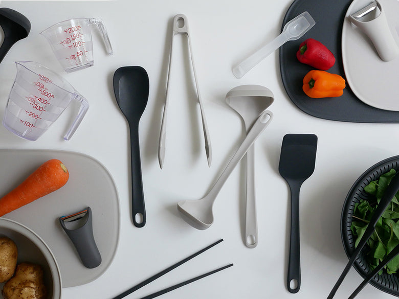 マーナのきほん ザルボウル21cmとスプーン、スパチュラなど多様なキッチン用品がテーブルに並ぶ様子