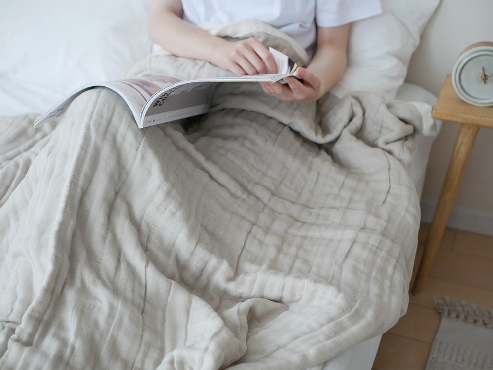 ココマニの綿100％5重織ガーゼケットがシングルサイズのベッドに敷かれている写真