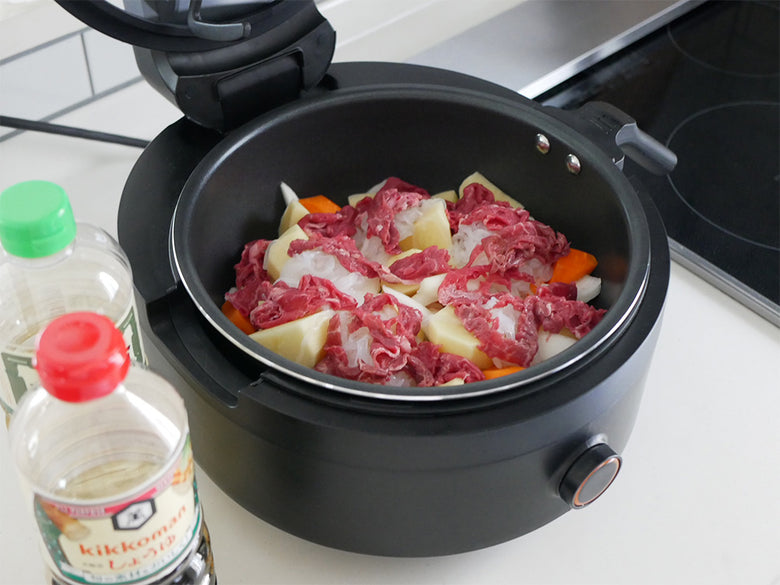 アイネクス全自動調理スマートオートクッカーで肉や食材を調理しているキッチンの様子