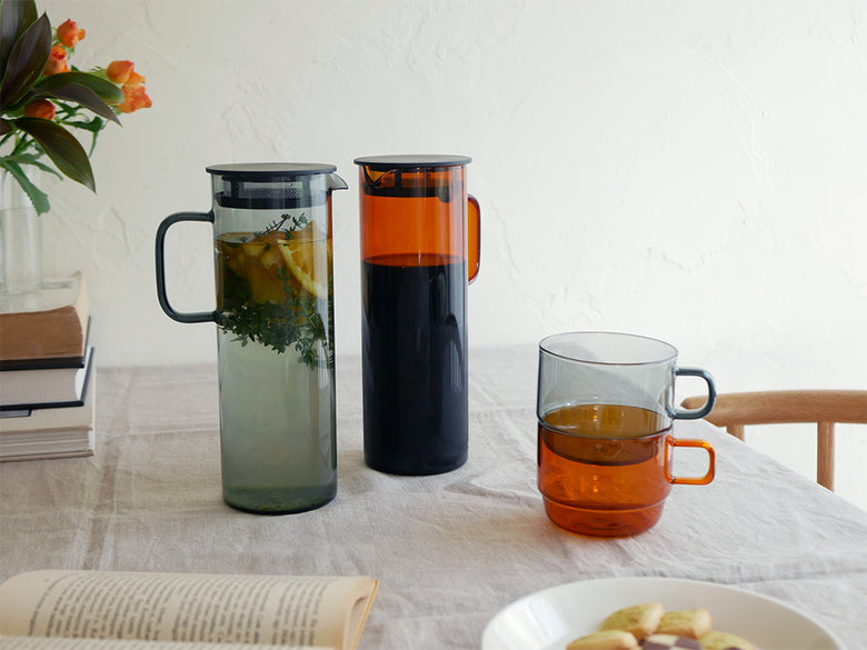 HARIOのコールドブリューピッチャーとグレーおよびアンバーのスタックマグカップのセット