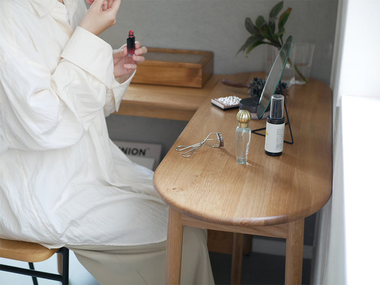 清潔感のある室内にオーク無垢材製の伸長可能なコンソールテーブル「SUK」が配置され、ランプや観葉植物がアクセントとなっています。