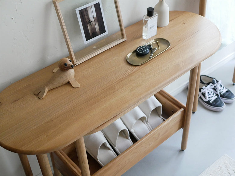 オーク無垢材で作られた引き出し付き伸長可能なコンソールテーブル「SUK」が室内に配置されている様子