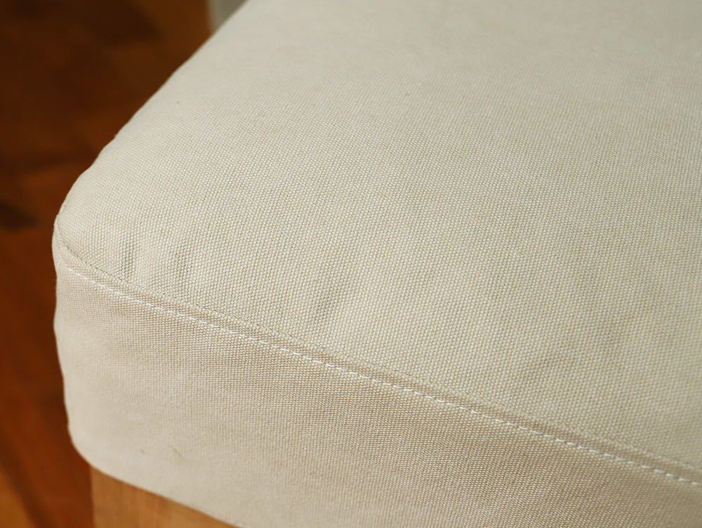 ブラウンとグレーの色合いが特徴的なアデペシュのソロソファーが、木目調の床に置かれている様子。