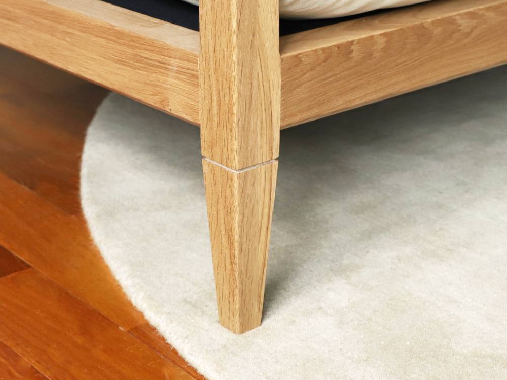 アデペシュのソロ2.5シートソファーが無垢オーク材の床に配置されたスタイリッシュなリビングルームの画像