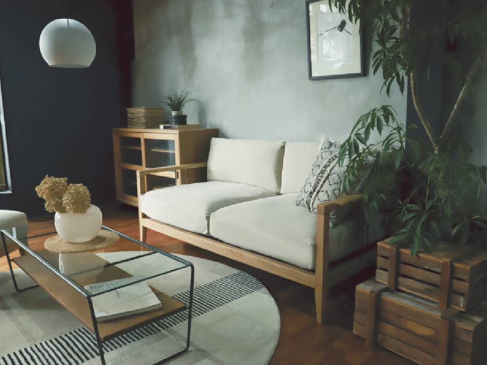 グレーのアデペシュsoloソファーとナチュラル素材のクッションが配置されたモダンなリビングルームのインテリア