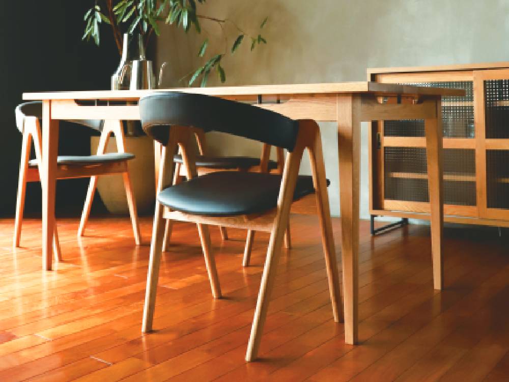 アデペシュのオーク製cobakホールドアームチェアが木製フローリングのリビングルームに配置されている様子