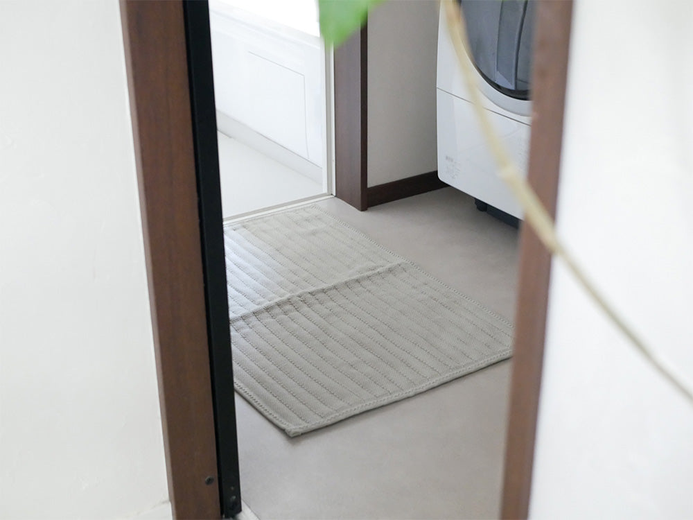 木製の床に敷かれた【OKATO】ゆったりサイズの足裏さらさらバスマット