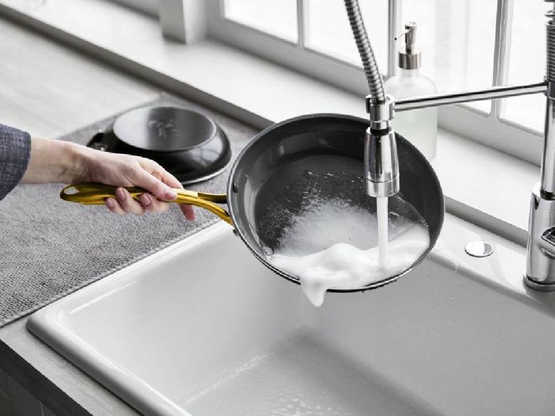 グリーンパンのストゥディオシリーズキャセロール、ソースパン、ミルクパンがキッチンの調理台に並べられている