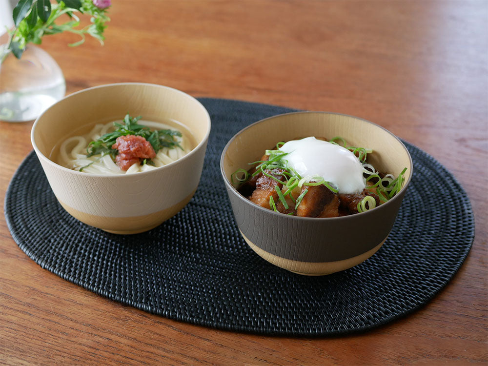 やさしい彩りシリーズの抗菌汁椀、抗菌丼、八角箸などの食器セットがテーブルに並んでいる画像