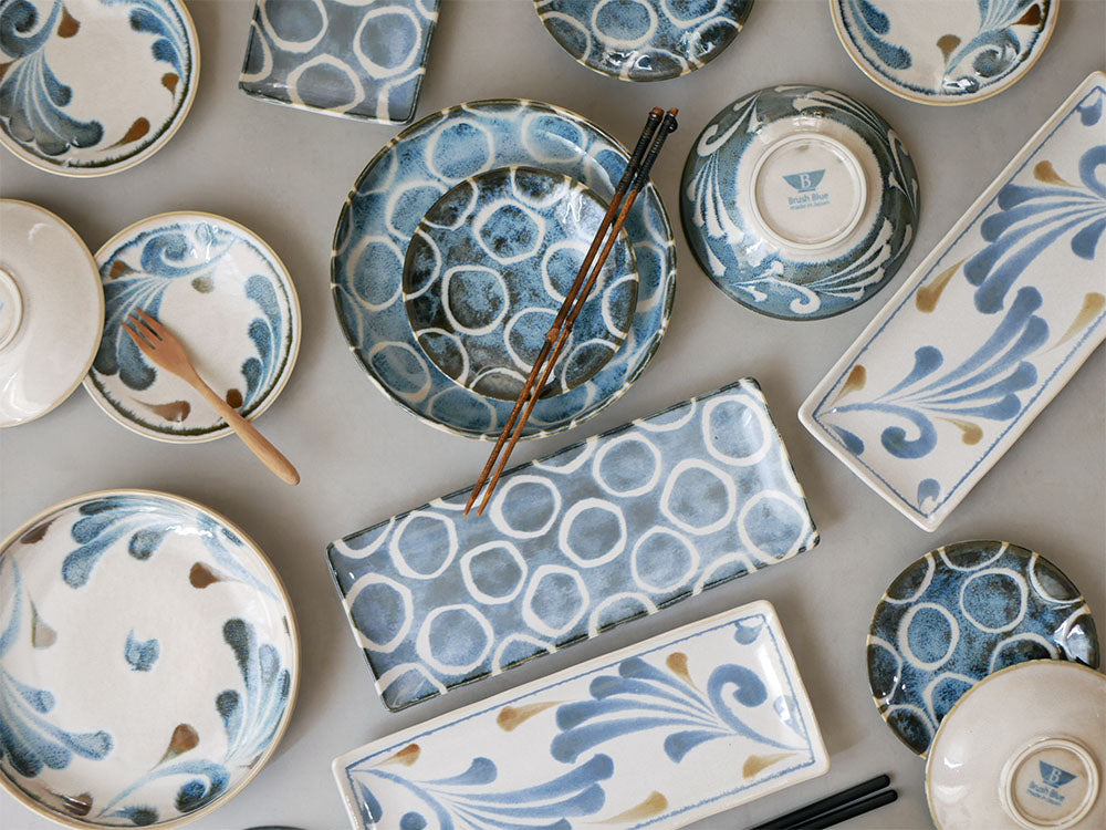 青いアワサカ製和モダン陶器ダイニングセット。パスタボウル、長角皿、プレート、スモールボウルがテーブルに並んでいる