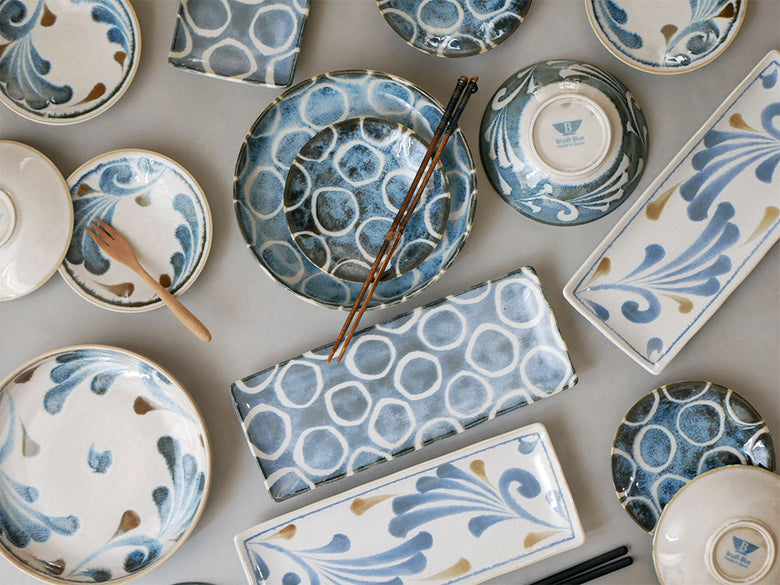 青いアワサカ製和モダン陶器ダイニングセット。パスタボウル、長角皿、プレート、スモールボウルがテーブルに並んでいる
