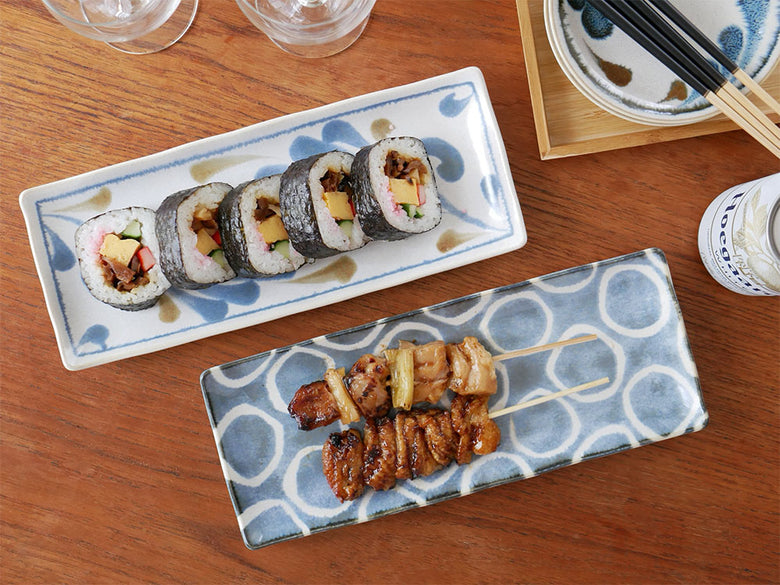 アワサカの和モダンな磁器製テーブルウェアに盛り付けられた寿司やカリフォルニアロールなどのフィンガーフード