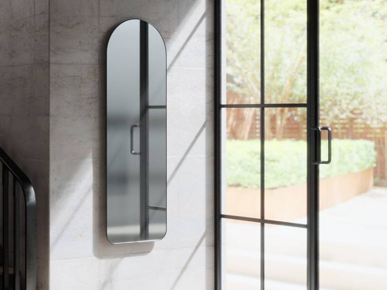 アンブラのフーバ アーチド リー二ングミラー。グレーとシルバーのハードウェアが特徴的なガラス製のバスルーム用モダンデザインの鏡、高さ157cm