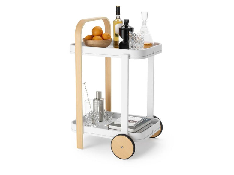 アンブラ製ベルウッド サービングカートがキッチンに配置され、調理器具や飲料ボトル、チェア、植物などが周囲に並んでいる様子