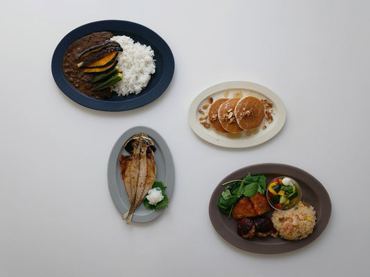 SAKUZANのSaraオーバルプレートに盛られた料理がテーブルにセットされた様子