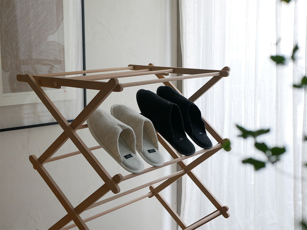 自然素材を使用したクローゼット内に、衣類ハンガー、衣類ホース、バッグ、ロープ、シェルビング、靴オーガナイザーなどの洗濯用品が整然と配置されている様子