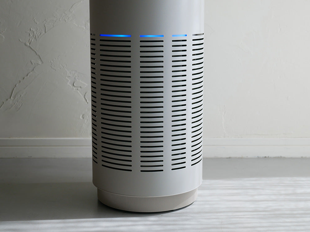 木製フローリングの上に置かれたcado LEAF 320i空気清浄機、シンプルでモダンなデザインの家庭用電子機器