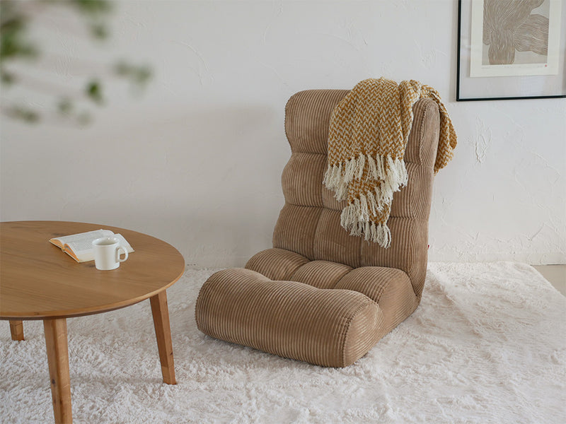 ピグレットのソファーみたいな座椅子が木製フローリングのリビングルームに配置され、ブラウンのクッションで快適な雰囲気を演出しています。
