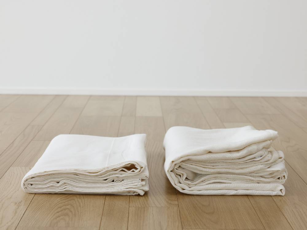 オーガニックコットン100％のココマニシングルサイズ布団カバーが木製の床の上に敷かれている写真
