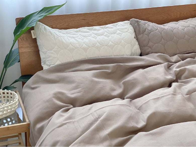 シングルサイズのオーガニックコットン布団カバーと枕が整えられたベッドルーム