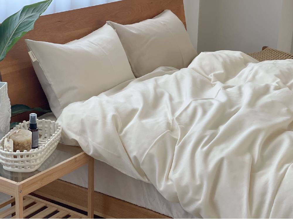 オーガニックコットンのココマニ布団カバーとクッションが整えられたシングルベッドの快適な寝室
