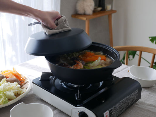 キントー KAKOMI 直火土鍋がポータブルストーブの上で調理されている様子