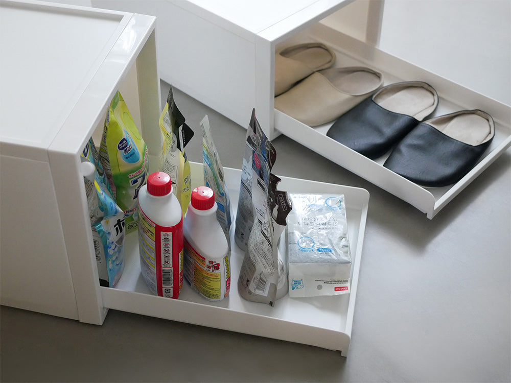 白色のライクイット クローゼットシステム引き出しオープントレータイプの棚に、プラスチック製のボックスや靴オーガナイザーが整理されて配置されている様子