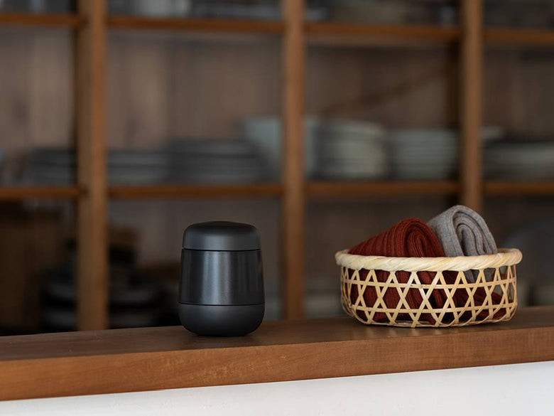 プラスマイナスゼロ毛玉クリーナーの円筒形本体。ABS樹脂とプラスチックで作られ、蓋が付いており、LEDインジケーターとスピーカーが搭載されています。