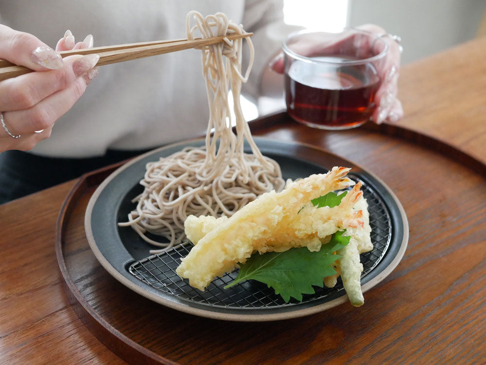 キキメの網付きプレートに盛られたそばと中華麺、箸が置かれた食卓