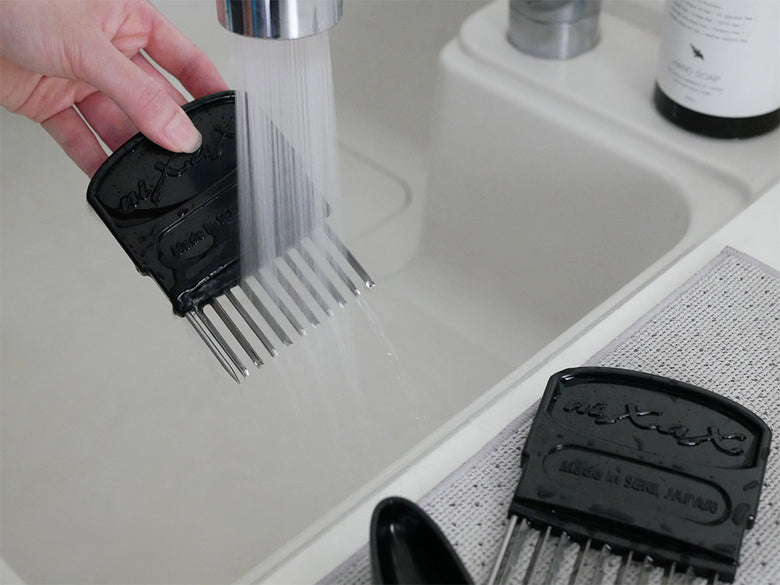 銀色のキッチンシンクに蛇口と排水装置が備わったキッチンの写真