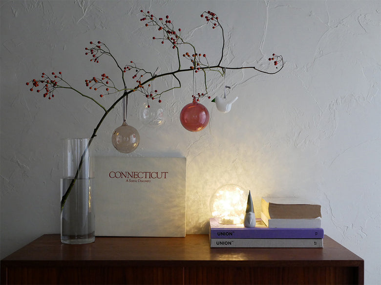 枝や果実とともにディスプレイされたイッタラの無鉛ガラスオーナメントセットの静物写真