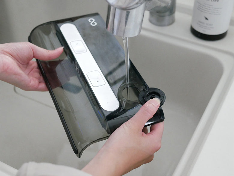 ミンドー AquaX 掃除機本体と充電スタンド、ロールブラシ、フィルターなどの付属品が並んだシルバーの家庭用電子機器