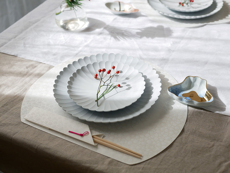アマブロ MAMEの日本製磁器テーブルウェアセットが美しく並べられた食卓の様子。吹墨富士形皿や牡丹蝶文角皿など多彩なデザインのプレートがテーブルクロスと共に配置されています。
