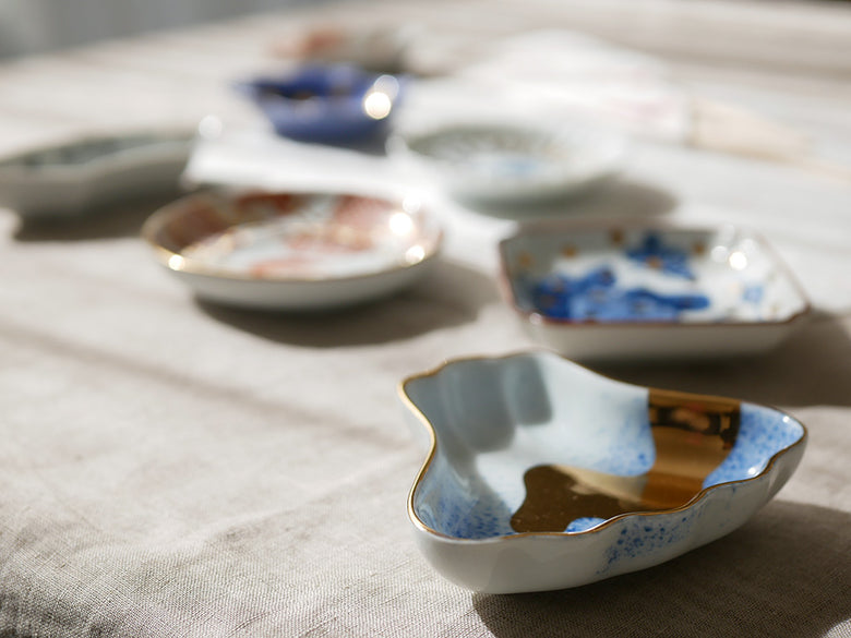 アマブロ MAMEシリーズの磁器食器セット。吹墨富士形皿や丸散赤丸など、多彩なデザインのプレートが並んでいます。