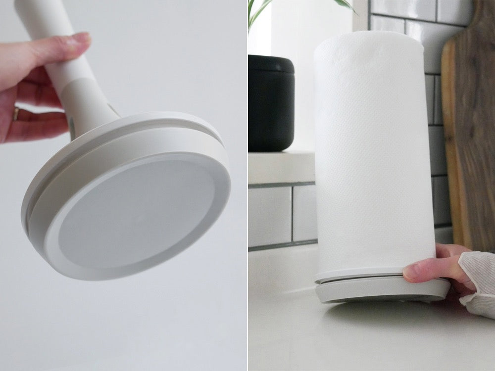 マーナ製の倒れない片手操作キッチンペーパーホルダー。ABS樹脂とポリアセタール素材を使用した安定した円筒形デザインがキッチンカウンターに設置されています。