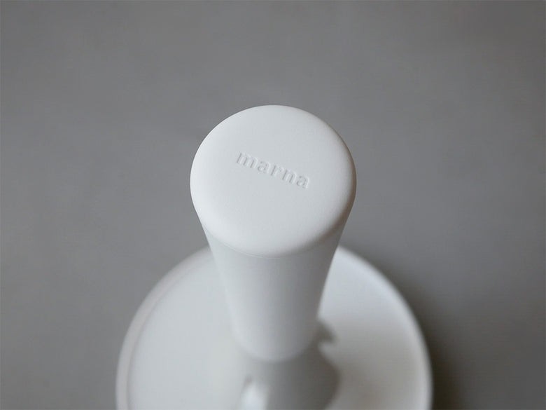 白色のプラスチック製「マーナ」キッチンペーパーホルダー。片手で簡単に紙を取り出せ、倒れにくいデザインが特徴です。