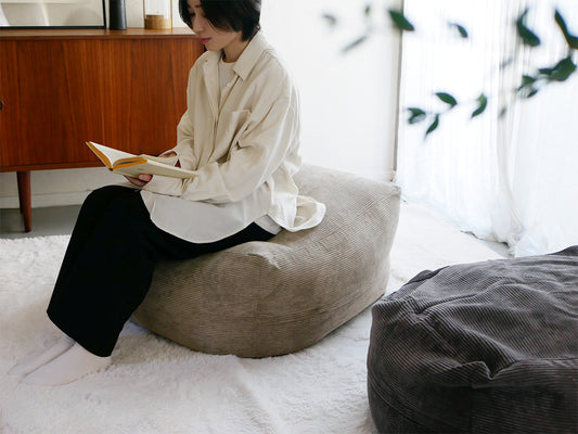 リビングルームに置かれたQUBE/キューブのグレーコーデュロイビーズビーンバッグチェア