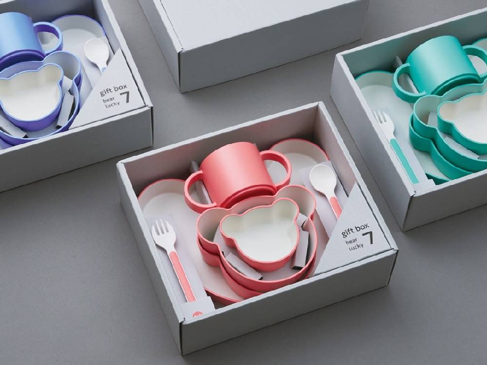 ベアがデザインされたキッズディッシュギフトボックスに、マグカップやプレート、カトラリーがセットされている様子