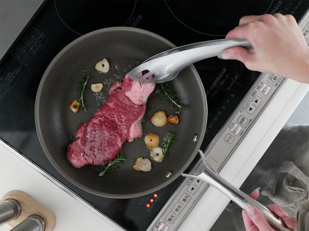 CORELLEコレールのこびりつきにくいステンレス製フライパンで野菜を調理しているキッチンの様子