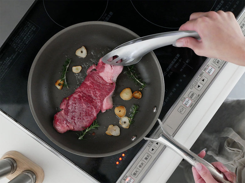 CORELLEコレールのこびりつきにくいステンレス製フライパンで野菜を調理しているキッチンの様子