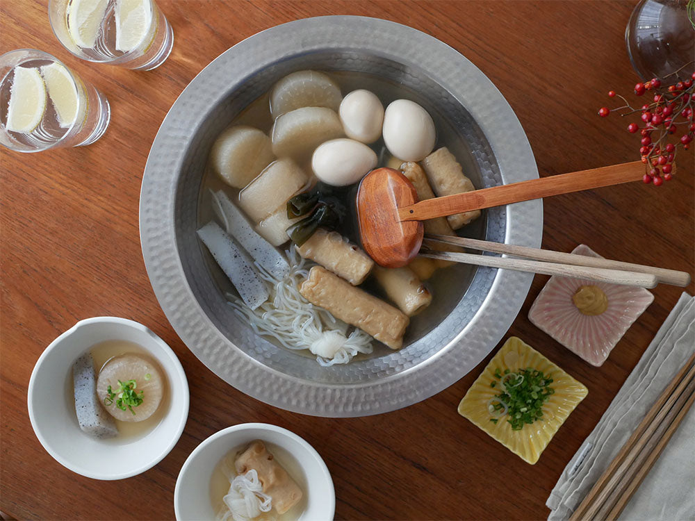アーネストのとにかく洗いやすいステンレス卓上鍋とのせるだけ蒸し器が食卓に並び、スープや料理が盛り付けられている様子