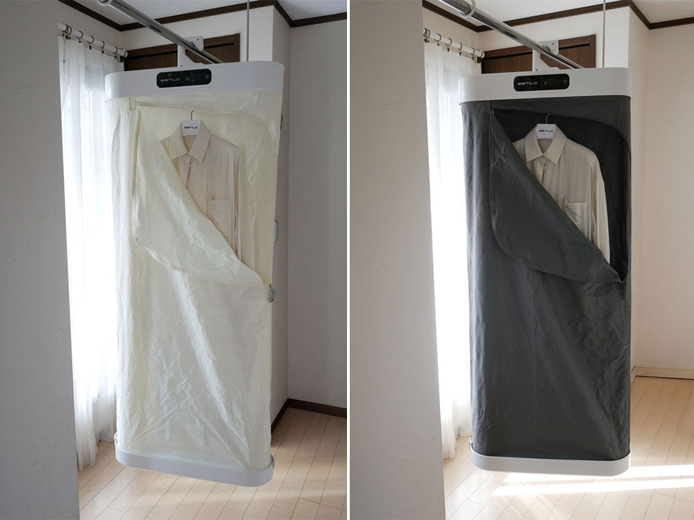ESTILOエスティロスチームイオンリフレッシャーがカーテンや衣類ハンガーとともに清潔なリネンと配置されたクローゼット内の様子