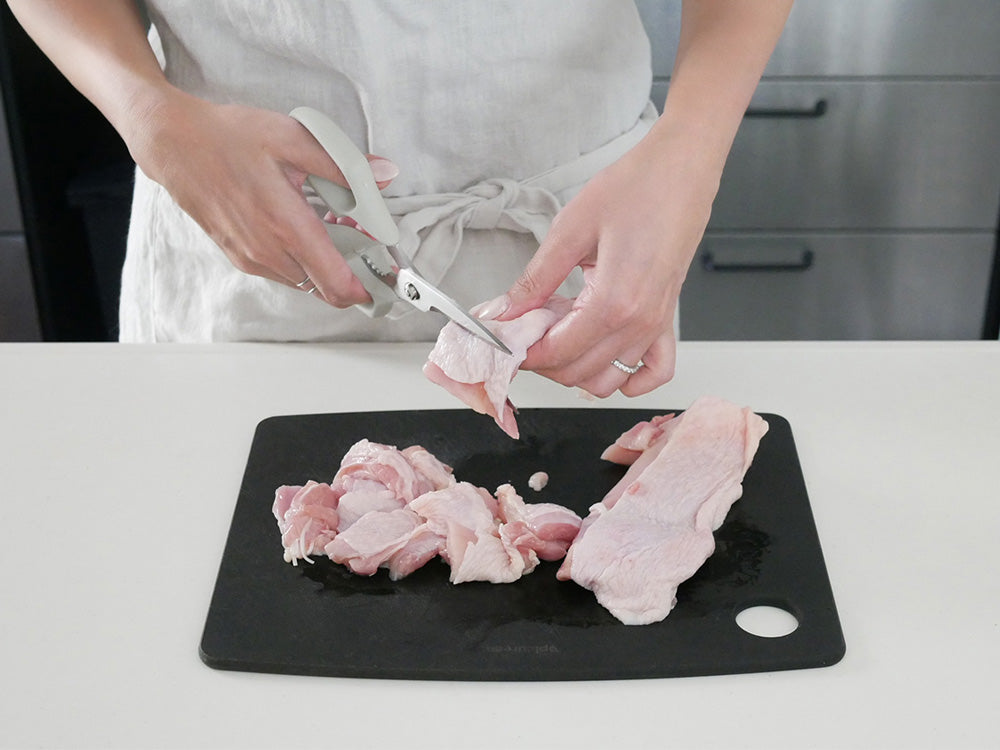 協和工業のムテキバサミがまな板の上で鶏肉を切っている調理シーン